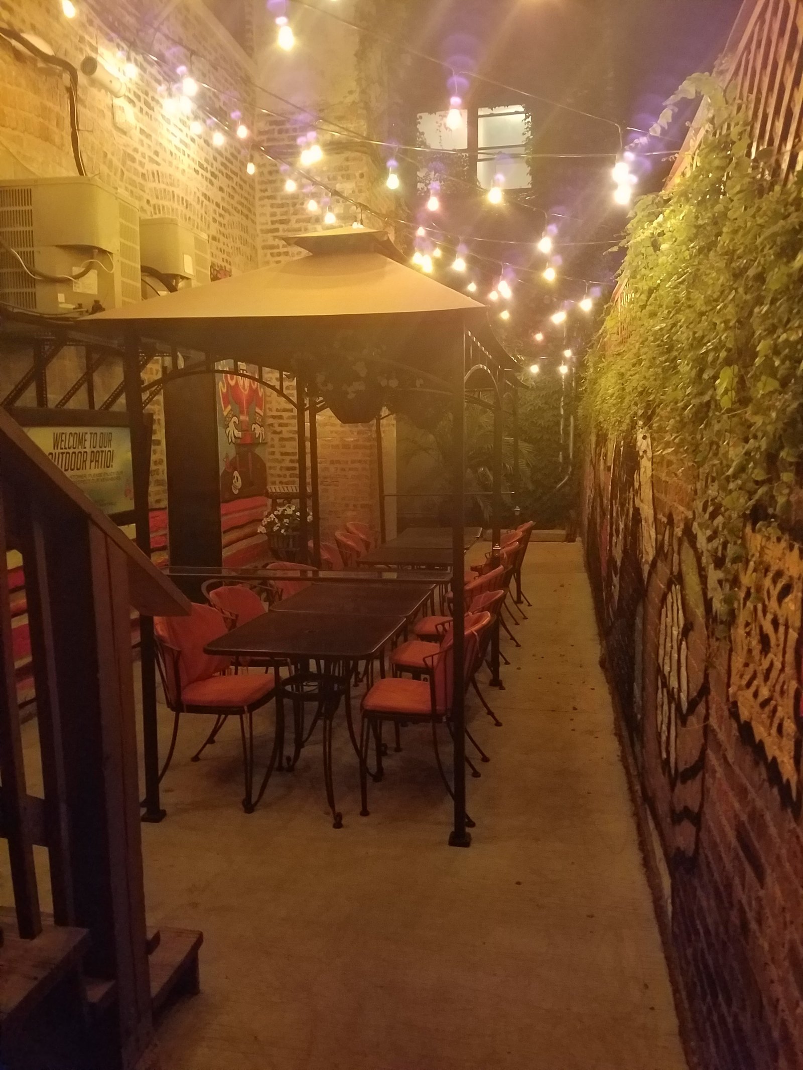 Outdoor patio with string lights and umbrellas at night